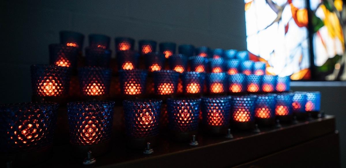 Votive candles burn in the chapel as a prayer offering